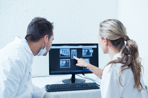 Two coworkers reviewing dental x-rays